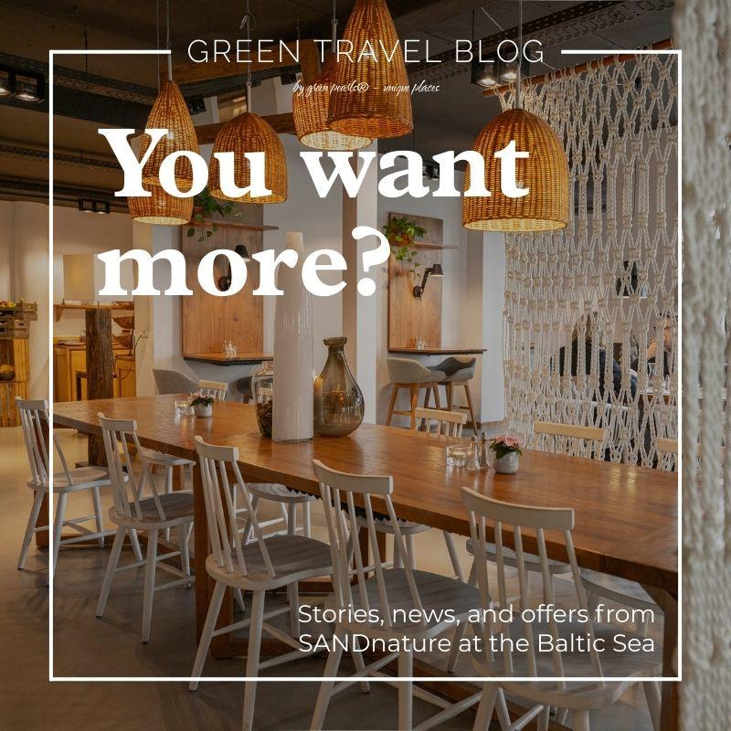Cozy café interior with wooden tables, white chairs, wicker lamps, and plants. Text overlay reads "You want more? Stories, news, and offers from SANDnature at the Baltic Sea." Earthy, inviting atmosphere.