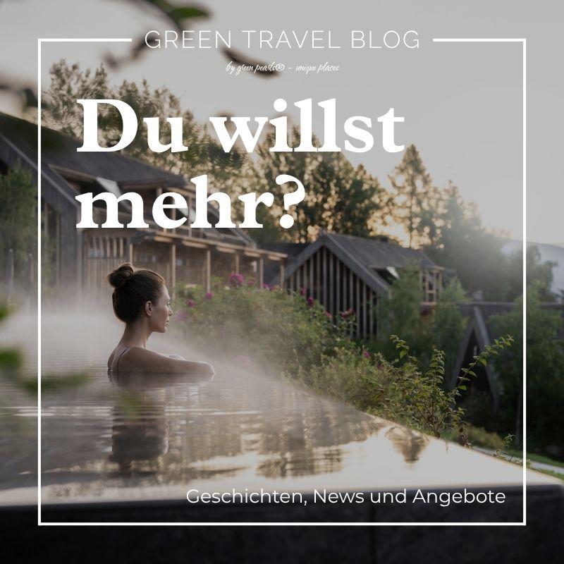 Frau mit zusammengebundenem Haar entspannt in einem Außenpool mit Dampf vor Holzhäusern und Bäumen