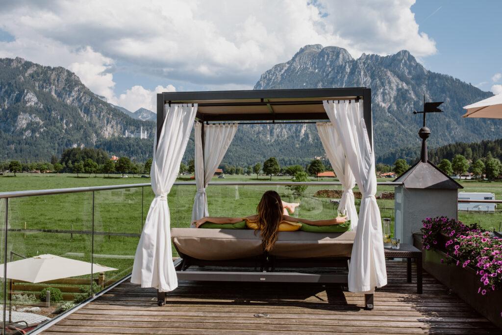 Panoramadeck mit Day Bed im nachhaltigen Hotel Das Rübezahl mit Blick auf das bayerische Schloss Neuschwanstein