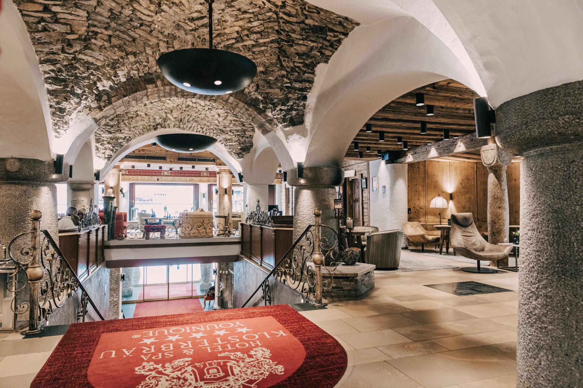 View of the lobby and entrance area of the Hotel Klosterbräu. In the foreground is a magnificent staircase.