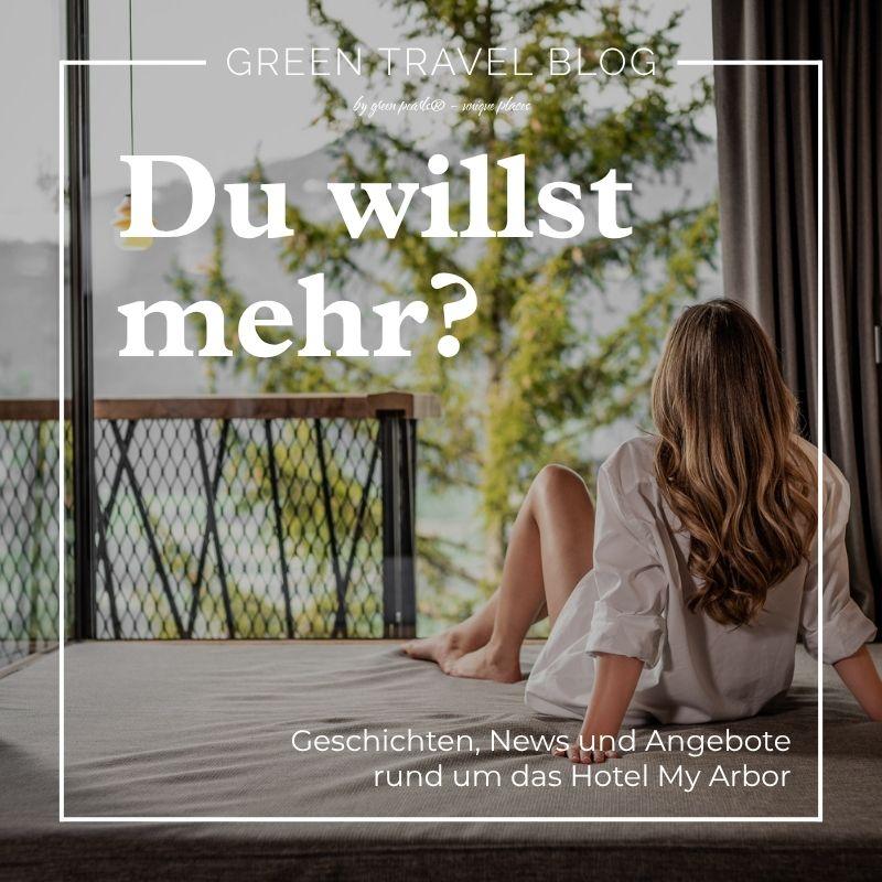 Eine junge Frau sitzt auf einem Bett im nachhaltigen Wellnesshotel My Arbor und schaut zu den Bergen und Baumwipfeln