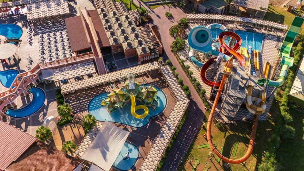 Let's take a look at the cool water park at the GSTC-certified Megasaray Club Belek in Turkey, with its winding slides, numerous pools, sun loungers, and lush greenery. The atmosphere is really great and a lot of fun.