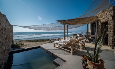 Terrasse mit Steinmauern, Holzliegestühlen, kleinem Pool, Topfpflanzen und einem Sonnenschirm mit Netz, mit Blick auf den Ozean / Suite im Inkaterra Cabo Blanco in Peru