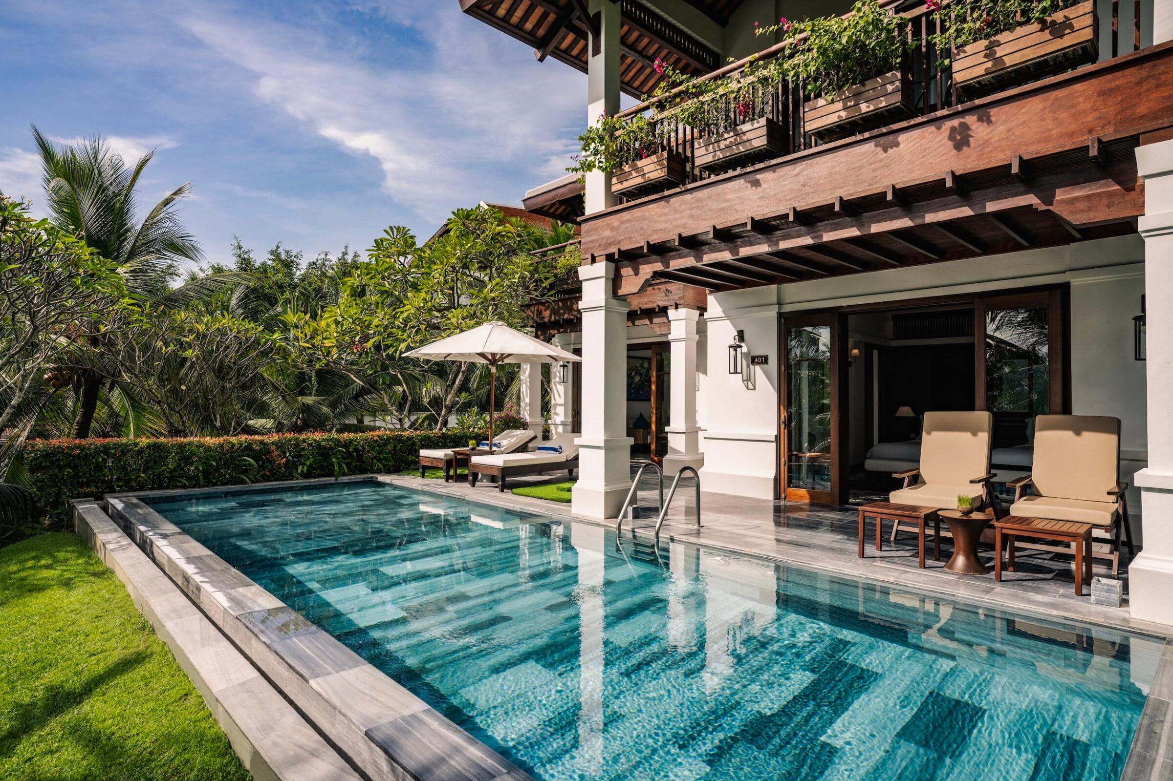 Poolvilla mit zwei Schlafzimmern auf einem Hügel, mit rechteckigem Pool, Liegestühlen, Sonnenschirm und tropischer Vegetation im Resort „The Anam Cam Ranh“ in Vietnam