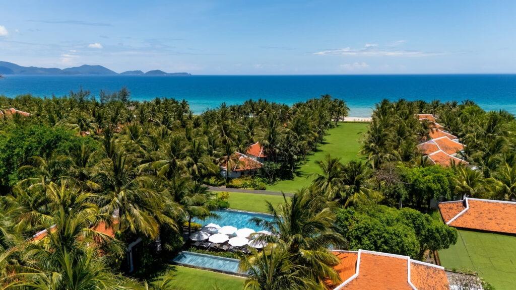 Luftaufnahme der luxuriösen Villen im Resort „The Anam Cam Ranh“ mit Pool, Palmen und dem Meer im Hintergrund
