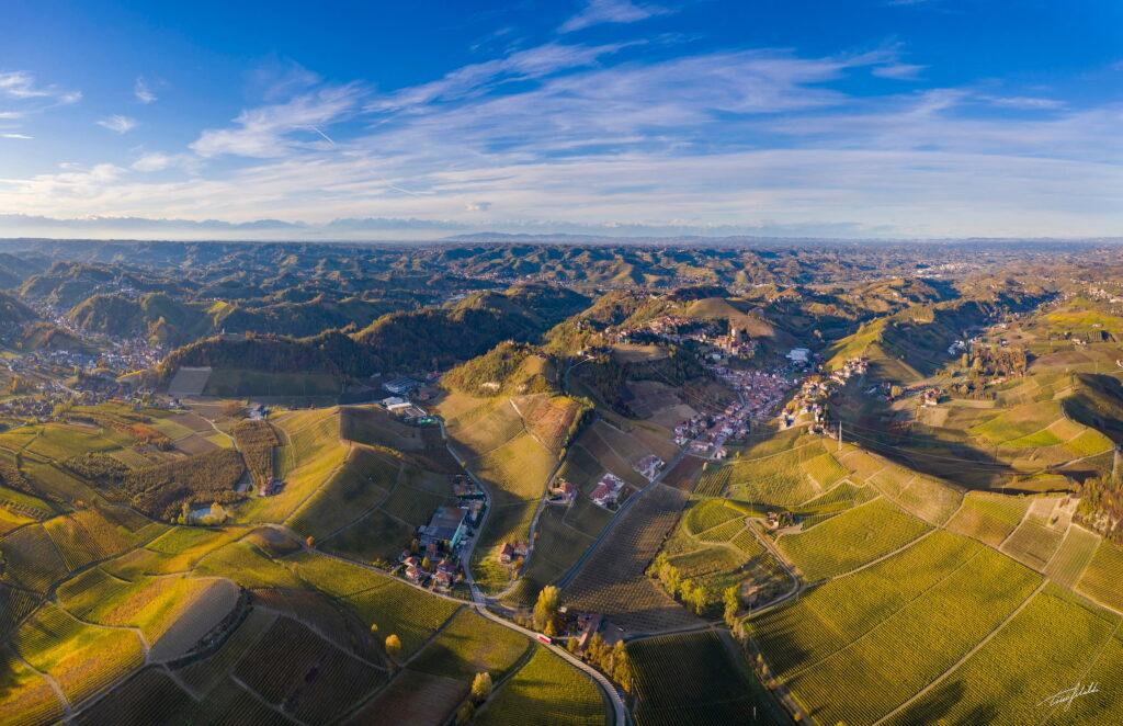 Aerial view of the rolling vineyard landscape dotted with villages in the Piedmont region