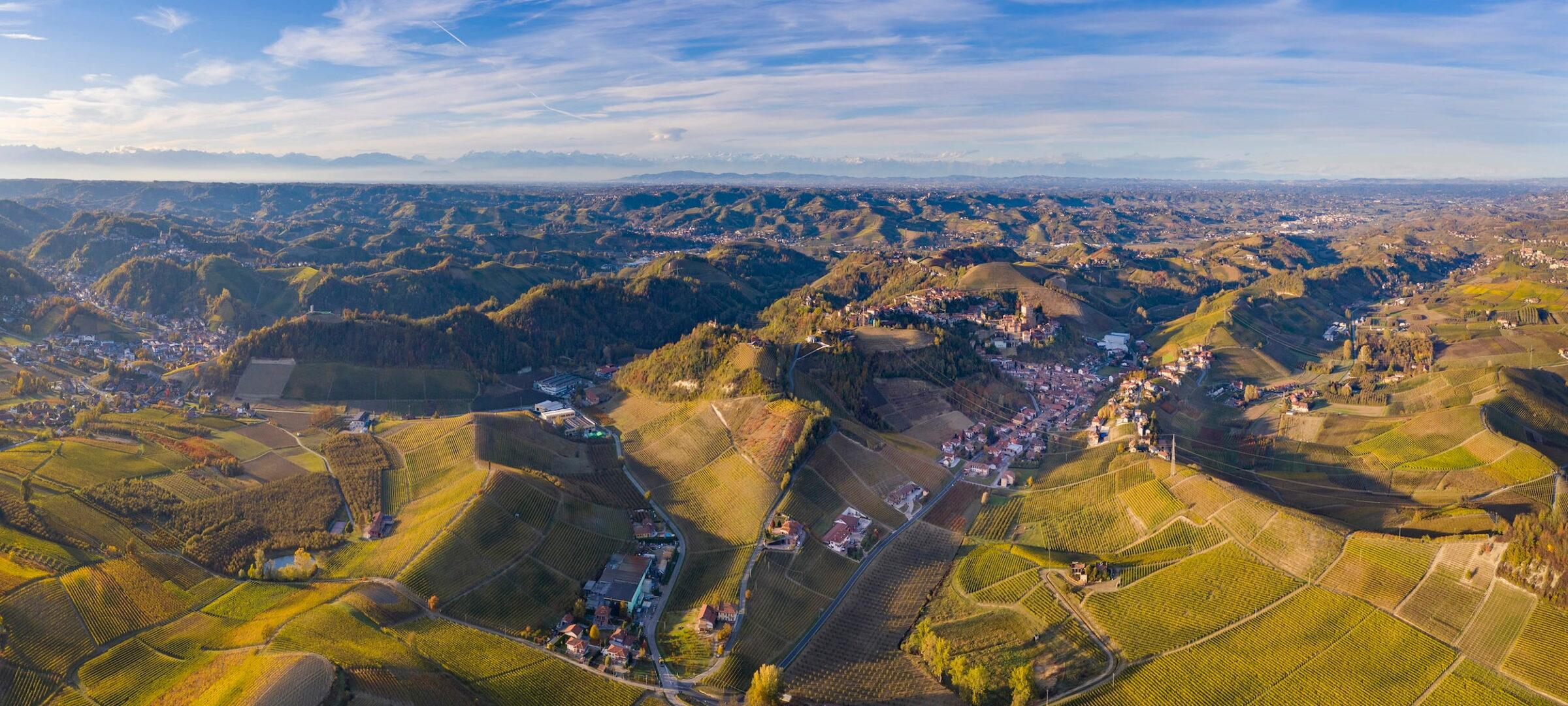 Aerial view of the rolling vineyard landscape dotted with villages in the Piedmont region