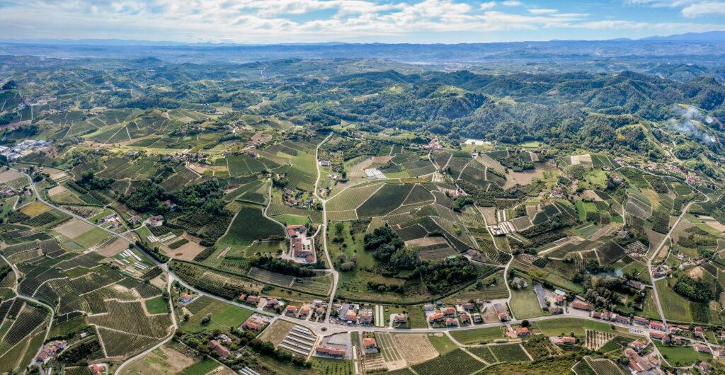 Aerial view of the rolling countryside of Roero in Piedmont, with vineyards, fields, and scattered buildings